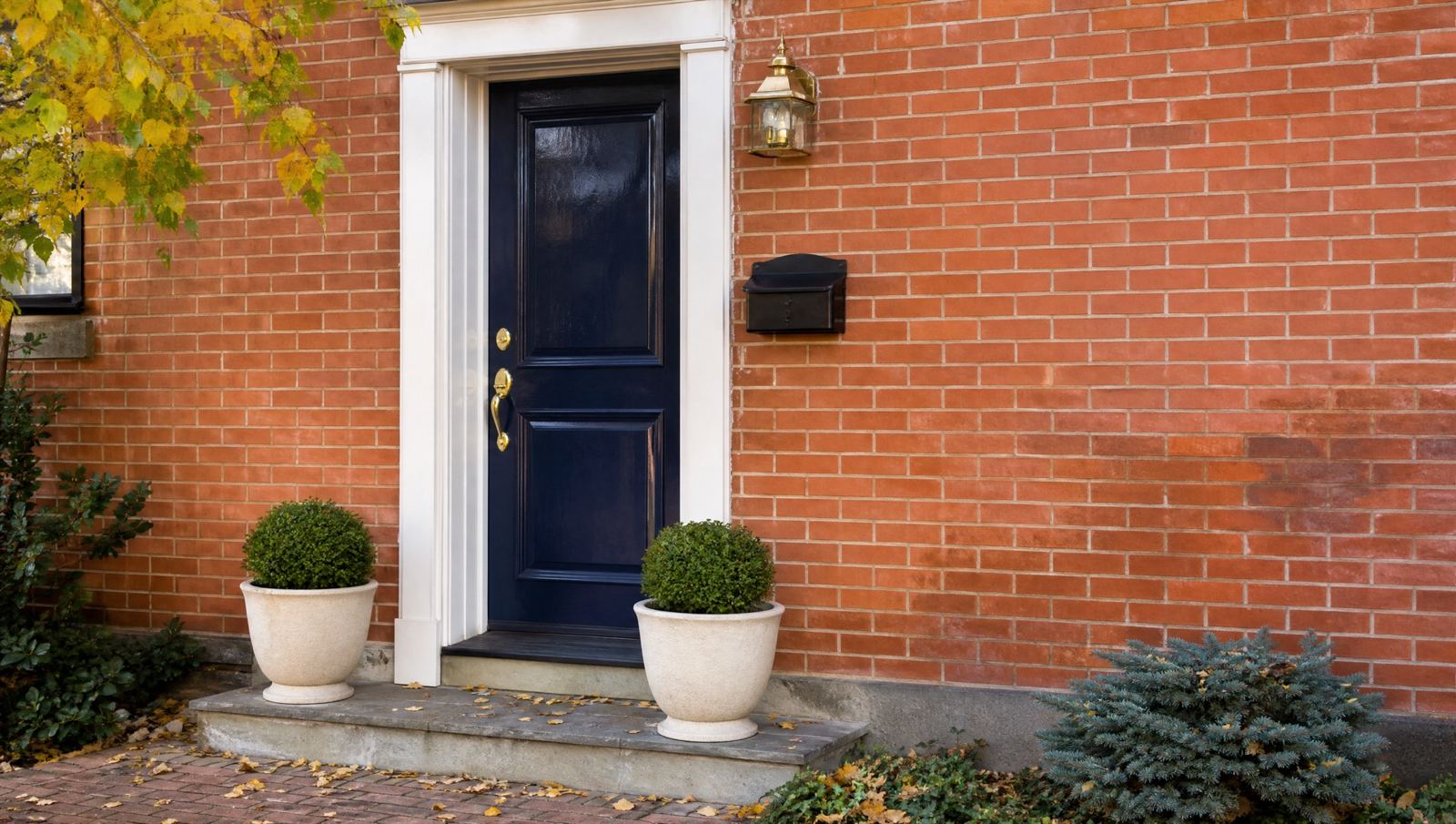 A navy front door on a brick house.